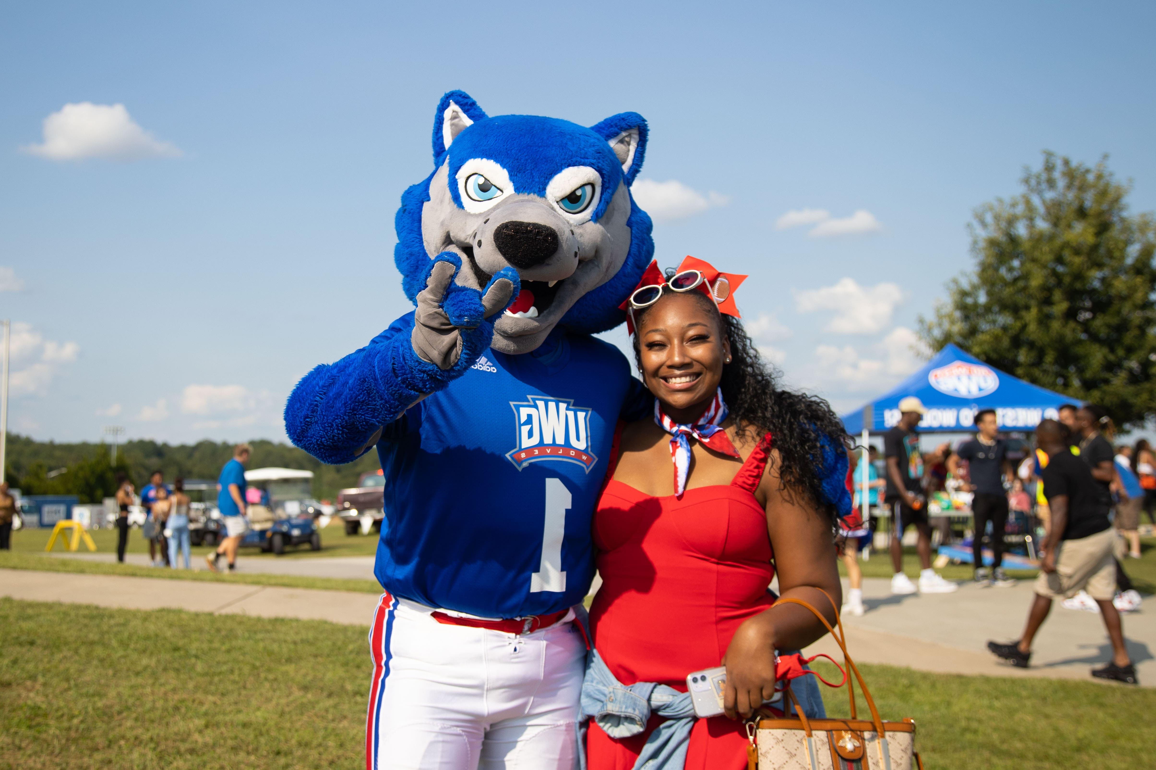 Wolfie with student at football game.